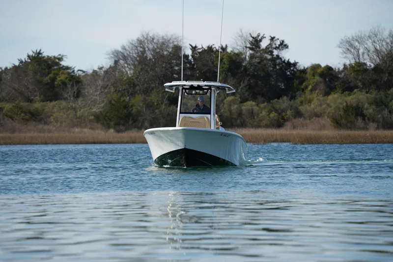 Slide: The Image of 2023 Sportsman Masters 267 Bay Boat cruising on calm water near a wooded shoreline. - 4