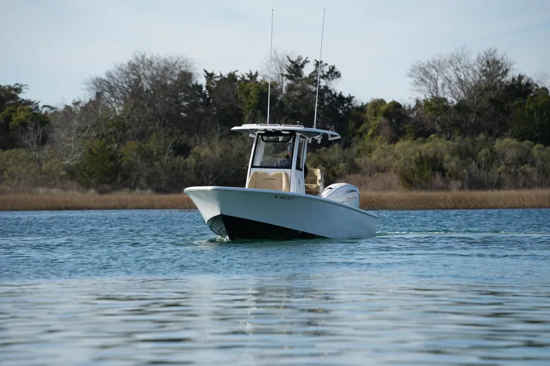 Slide: The Image of 2023 Sportsman Masters 267 Bay Boat cruising on calm water near shoreline. - 5