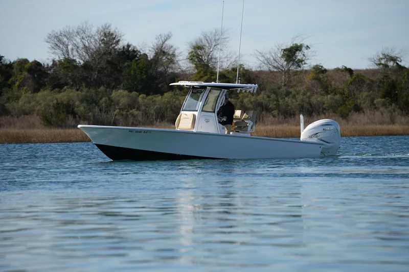 Slide: The Image of 2023 Sportsman Masters 267 Bay Boat cruising on calm water near shoreline. - 7
