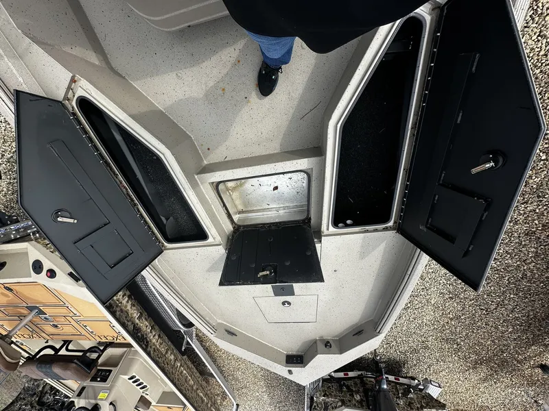 Slide: The Image of 2026 Excel 220 Bay Pro Elite boat with open storage compartments. - 5