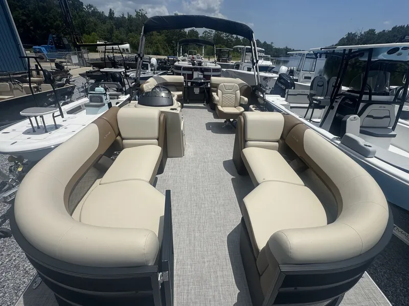 Slide: The Image of The image shows a 2026 Lowe LS Walk Thru 210 pontoon boat with beige seating and an open deck. - 5
