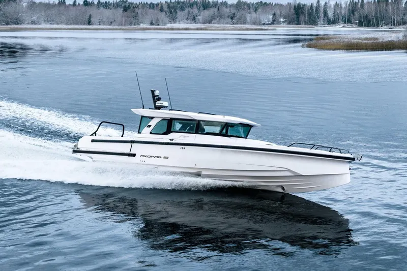 Slide: The Image of 2026 Axopar 38 Cross Cabin boat navigating icy waters, front view. - 3