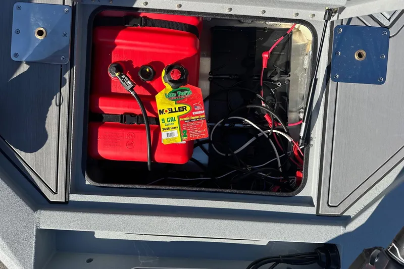 Slide: The Image of Open compartment of 2026 Avid 16 Commander boat showing red fuel tank and wiring. - 12