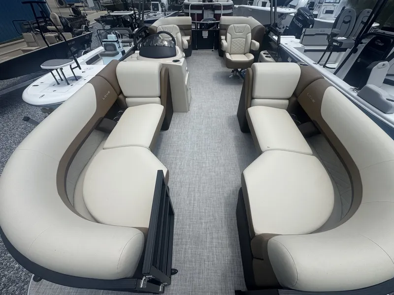 Slide: The Image of Lowe LS Walk Thru 210 pontoon boat with beige and brown seating, spacious layout, and helm console. - 9