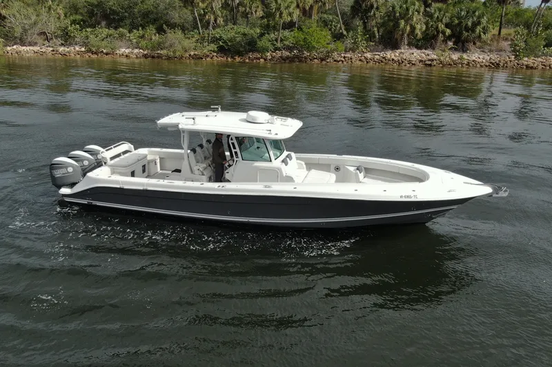Slide: The Image of 2018 HCB 39 Speciale boat cruising on calm water with lush greenery in the background. - 45