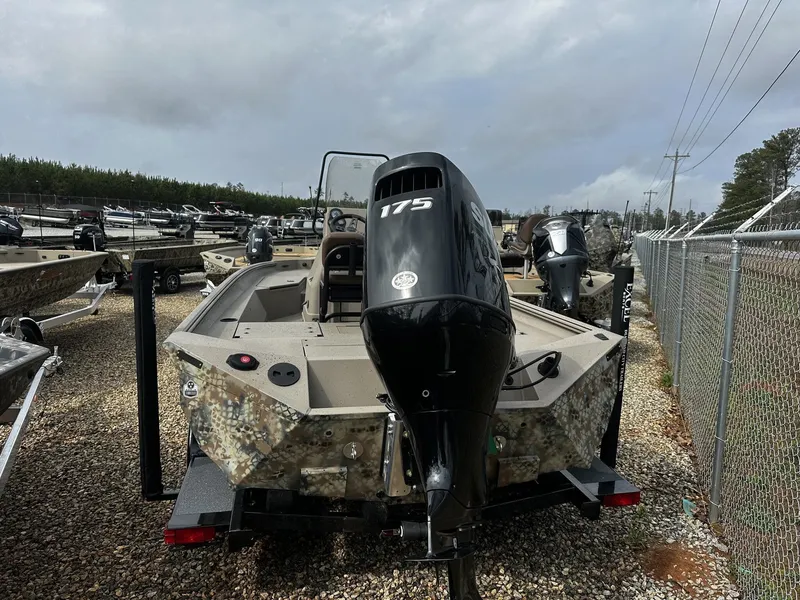 Slide: The Image of Excel 220 Bay Pro Elite 2026 with outboard motor on gravel lot. - 2