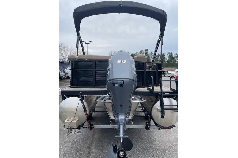 Slide: The Image of 2022 Bennington 20 SLX pontoon boat with 90 HP outboard motor, parked outdoors. - 4