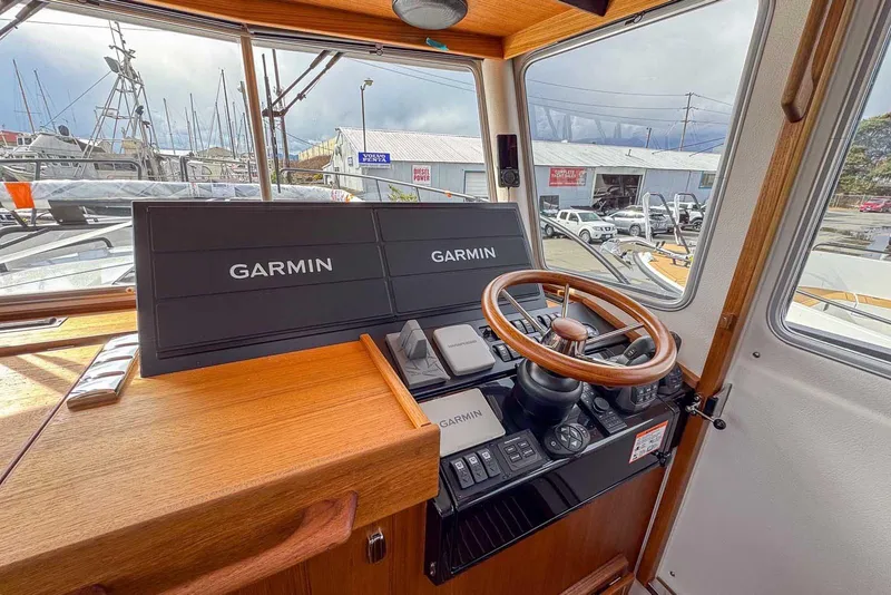 Slide: The Image of 2025 Targa 46 boat cockpit with Garmin navigation system and wooden steering wheel. - 14