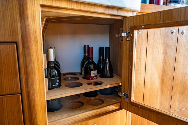 Slide: The Image of Wooden cabinet with wine bottles inside a Targa 46, 2025 model. - 19