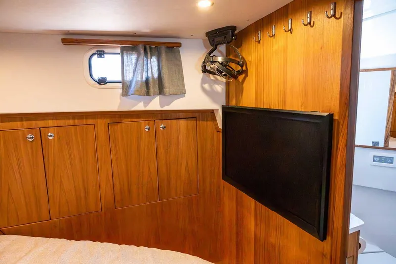 Slide: The Image of Cozy cabin interior of 2025 Targa 46 yacht with wood paneling and mounted TV. - 24
