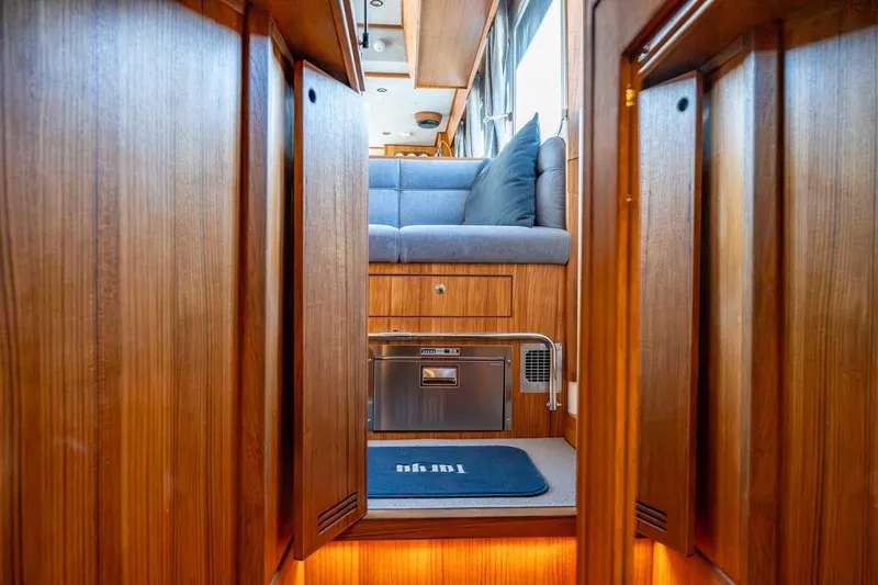 Slide: The Image of Luxurious interior of 2025 Targa 46 yacht with wooden finish and cozy seating area. - 25