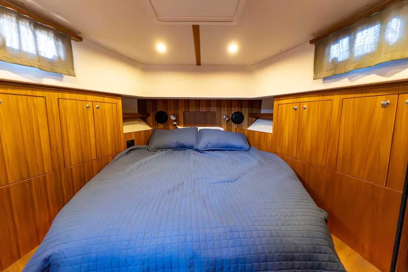 Slide: The Image of Luxurious cabin interior of 2025 Targa 46 yacht with cozy bedding and wooden cabinetry. - 26