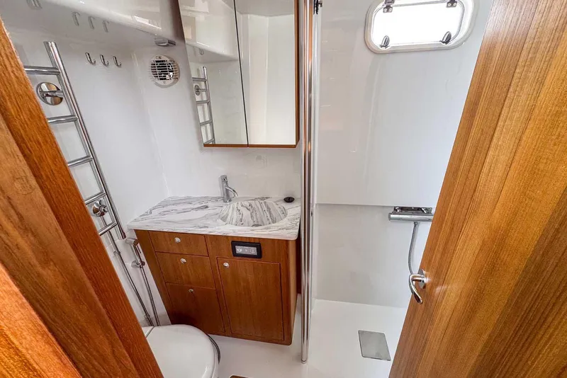 Slide: The Image of Luxurious bathroom in 2025 Targa 46 yacht with wood accents and marble countertop. - 32