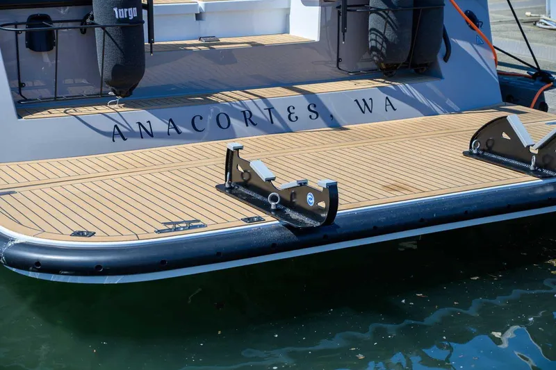 Slide: The Image of 2025 Targa 46 boat stern with Anacortes, WA lettering, docked on calm water. - 5