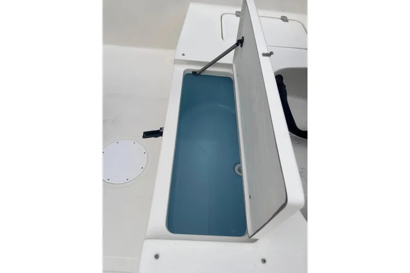 Slide: The Image of Open storage compartment on 2026 Bulls Bay 2000 boat, featuring a blue interior. - 20