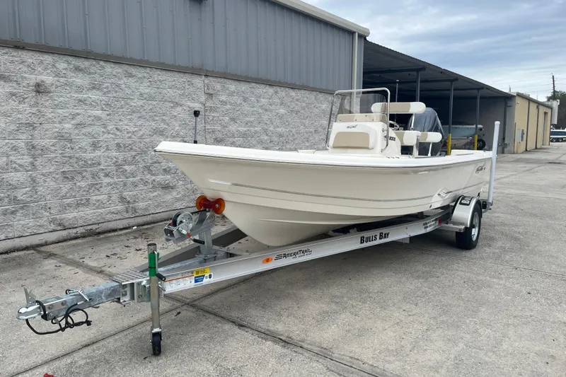 Slide: The Image of 2026 Bulls Bay 2000 boat on trailer, parked outside a warehouse. - 4