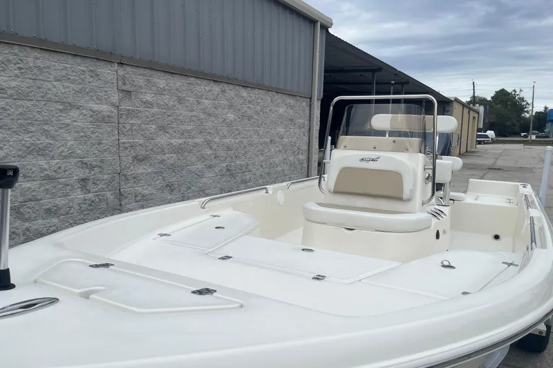 Slide: The Image of 2026 Bulls Bay 2000 boat, white exterior, parked near a warehouse under cloudy skies. - 7