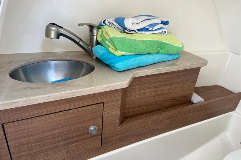 Slide: The Image of Interior of 2021 Boston Whaler 280 Vantage with sink and folded towels. - 10