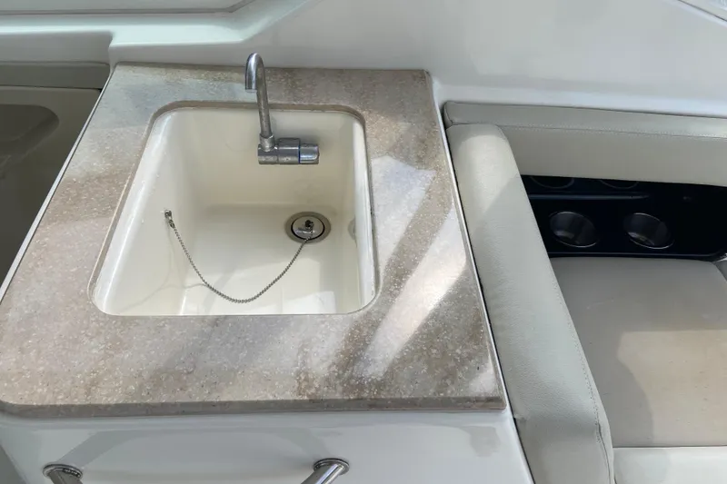 Slide: The Image of 2021 Boston Whaler 280 Vantage boat sink and seating area with cup holders. - 14