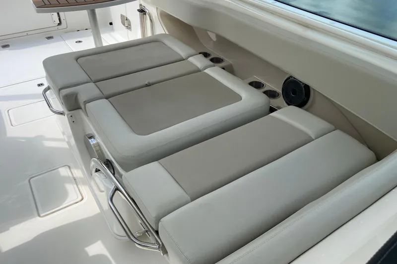 Slide: The Image of 2021 Boston Whaler 280 Vantage boat interior with cushioned seating and cup holders. - 24