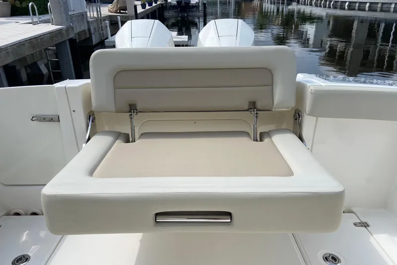 Slide: The Image of 2021 Boston Whaler 280 Vantage boat seat, beige upholstery, docked by water. - 28