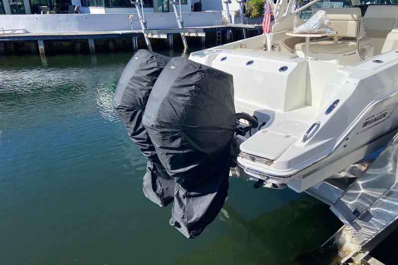 Slide: The Image of 2021 Boston Whaler 280 Vantage with covered outboard motors docked by the water. - 41