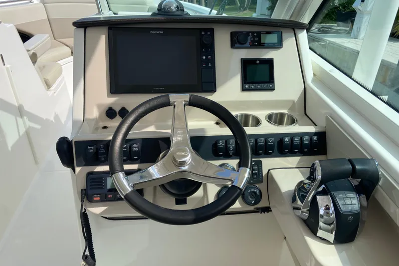 Slide: The Image of 2021 Boston Whaler 280 Vantage helm with steering wheel, controls, and navigation display. - 7