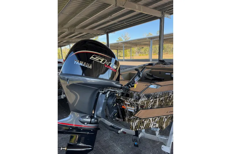 Slide: The Image of 2026 Avid 18 Commander boat with Yamaha outboard motor, parked under a metal canopy. - 3