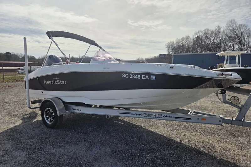 Slide: The Image of 2022 NauticStar 193 SC boat on trailer, parked outdoors under cloudy sky. - 3
