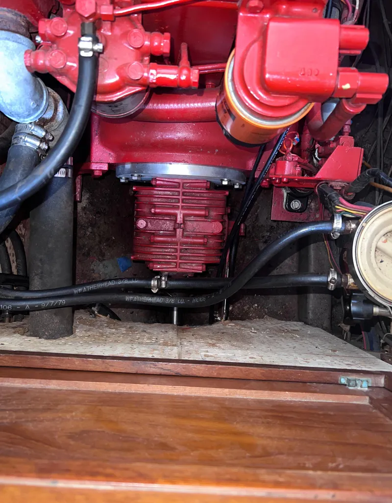 Slide: The Image of Engine compartment of a 1980 Lafitte 44 sailboat, featuring red mechanical components. - 43