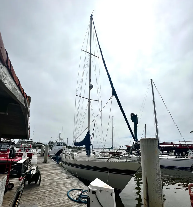 Slide: The Image of 1980 Lafitte 44 sailboat docked at a marina under a cloudy sky. - 5