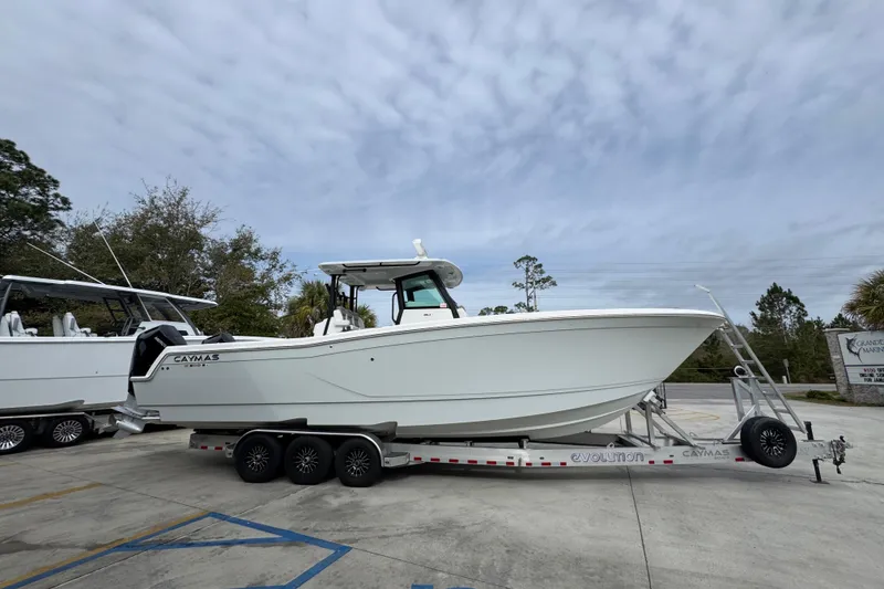Slide: The Image of 2024 Caymas 34 CT boat on trailer, parked outdoors under cloudy sky. - 10