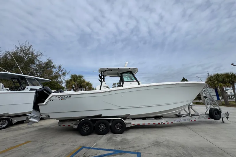 Slide: The Image of 2024 Caymas 34 CT boat on trailer, parked outdoors under cloudy sky. - 11