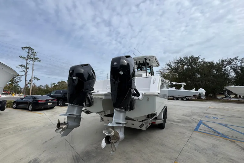Slide: The Image of 2024 Caymas 34 CT boat with dual outboard engines in a parking lot. - 15