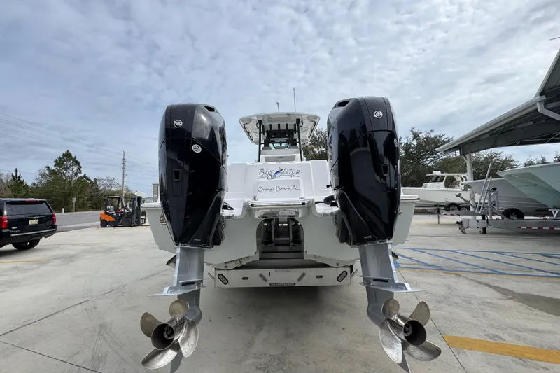 Slide: The Image of 2024 Caymas 34 CT boat with dual outboard motors, parked outdoors. - 16