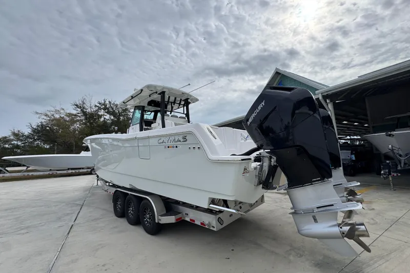 Slide: The Image of 2024 Caymas 34 CT boat with Mercury outboard engine on trailer, under cloudy sky. - 18