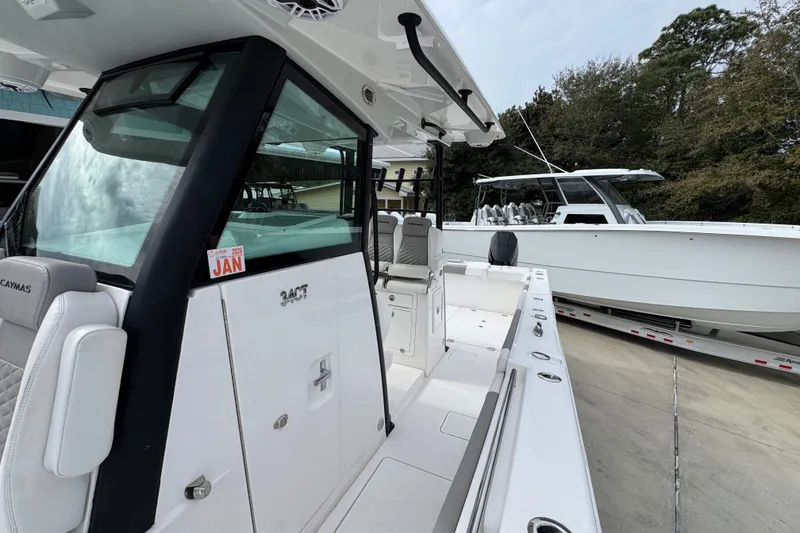 Slide: The Image of 2024 Caymas 34 CT boat, sleek design, docked outdoors with another boat in the background. - 24