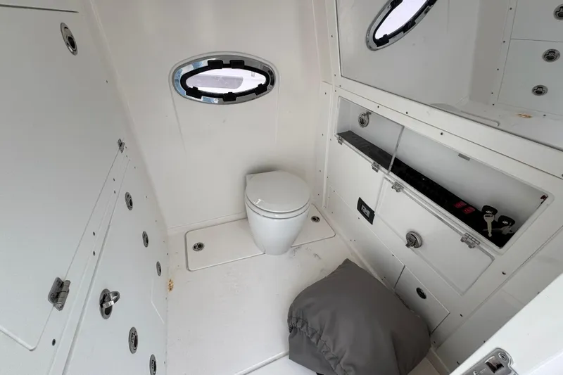 Slide: The Image of 2024 Caymas 34 CT boat interior bathroom with toilet and storage compartments. - 26