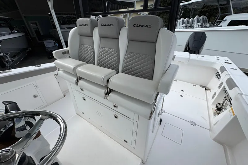 Slide: The Image of 2024 Caymas 34 CT boat interior with three cushioned seats and steering wheel. - 27