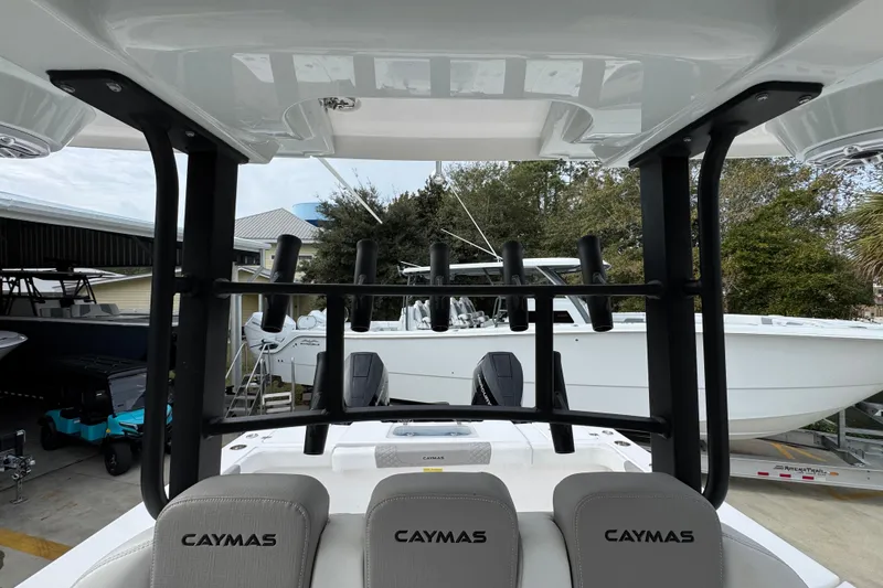 Slide: The Image of 2024 Caymas 34 CT boat interior with rod holders and seating, docked outdoors. - 29