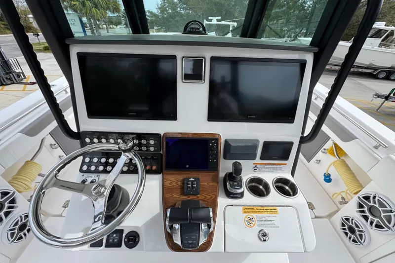 Slide: The Image of 2024 Caymas 34 CT boat dashboard with dual screens, steering wheel, and control panel. - 31