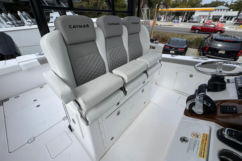 Slide: The Image of 2024 Caymas 34 CT boat interior with three cushioned seats and steering console. - 35
