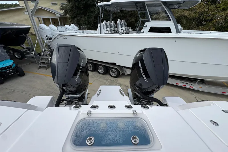 Slide: The Image of 2024 Caymas 34 CT boat with dual Mercury outboard engines, docked on a trailer. - 41