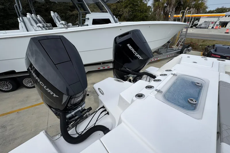 Slide: The Image of 2024 Caymas 34 CT boat with dual Mercury outboard engines, docked on a trailer. - 43