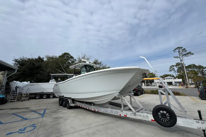 Slide: The Image of 2024 Caymas 34 CT boat on trailer, parked outdoors under cloudy sky. - 8