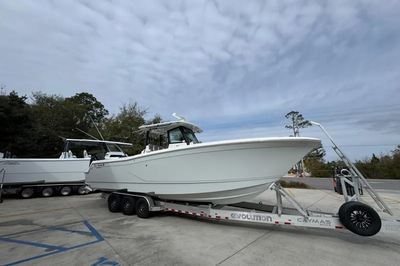 Slide: The Image of 2024 Caymas 34 CT boat on trailer, parked outdoors under cloudy sky. - 9