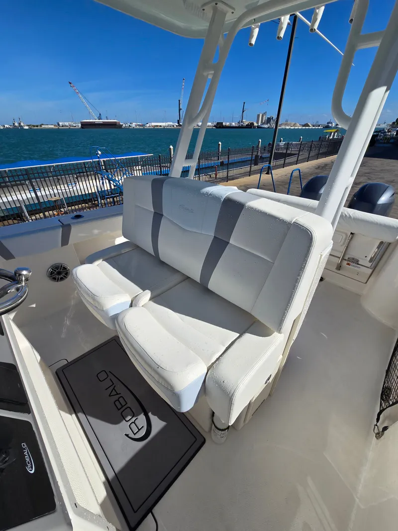 Slide: The Image of 2022 Robalo R272 Center Console with white seating by the water. - 25