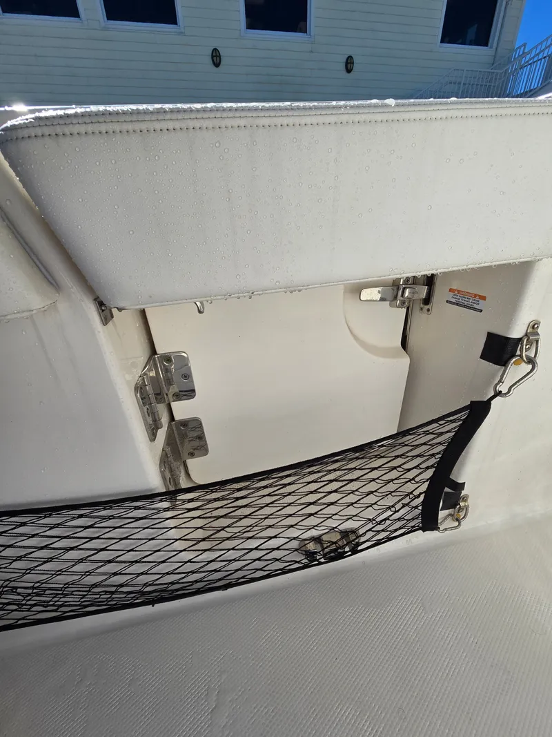 Slide: The Image of Robalo R272 Center Console 2022, storage compartment with netting and hinges. - 31