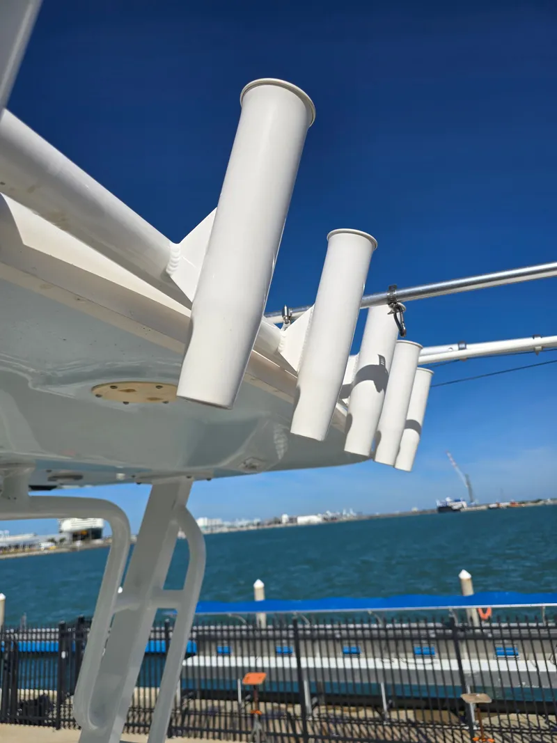 Slide: The Image of Robalo R272 Center Console 2022 with fishing rod holders by the water. - 36