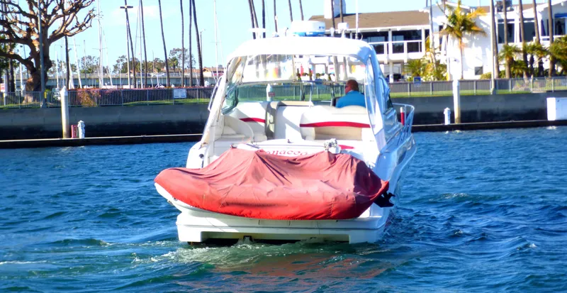 Slide: The Image of 2003 Formula 37 PC boat cruising in marina with red cover on rear. - 1